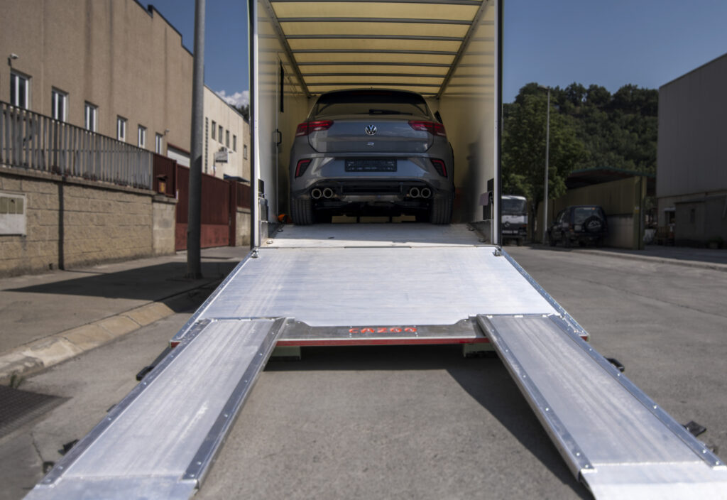 Novedades 2026: Interior del camion remolque premium de Importwagen protegiendo un coche deportivo durante su transporte e importación hacia Andorra.