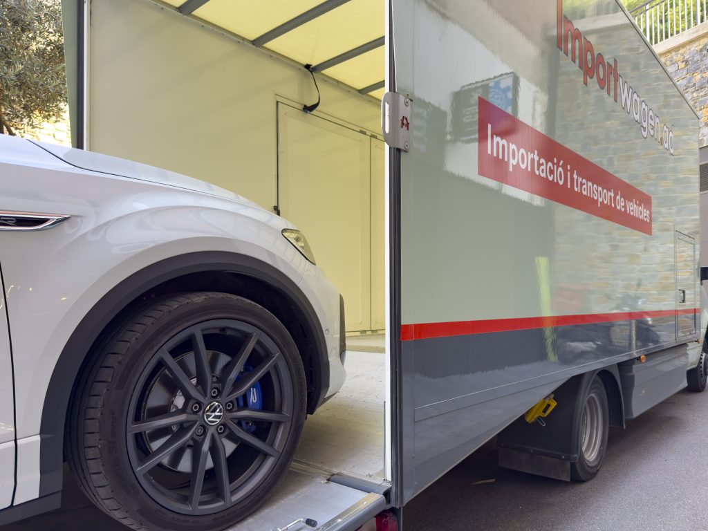 Un SUV blanco siendo descargado de forma segura tras mudarse a Andorra, un proceso facilitado por el servicio de importación de coches en Andorra de Importwagen.