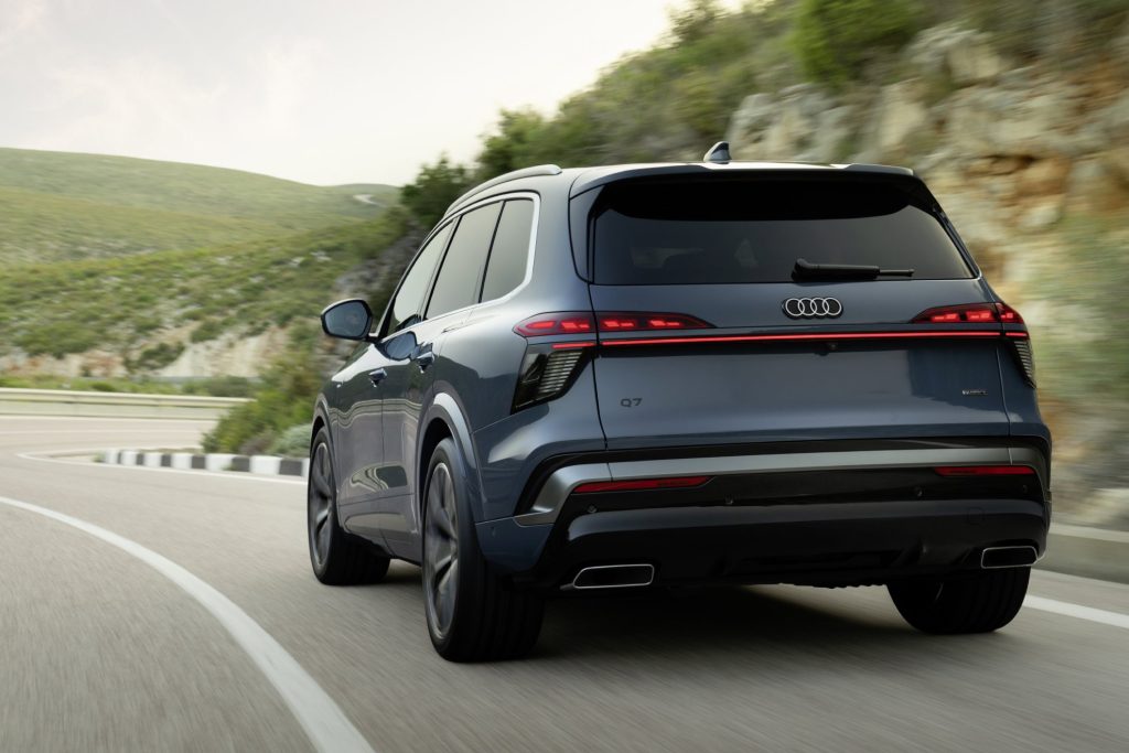 Vista trasera en movimiento del nuevo SUV Audi Q7 circulando por carretera, analizado por Importwagen en Andorra.